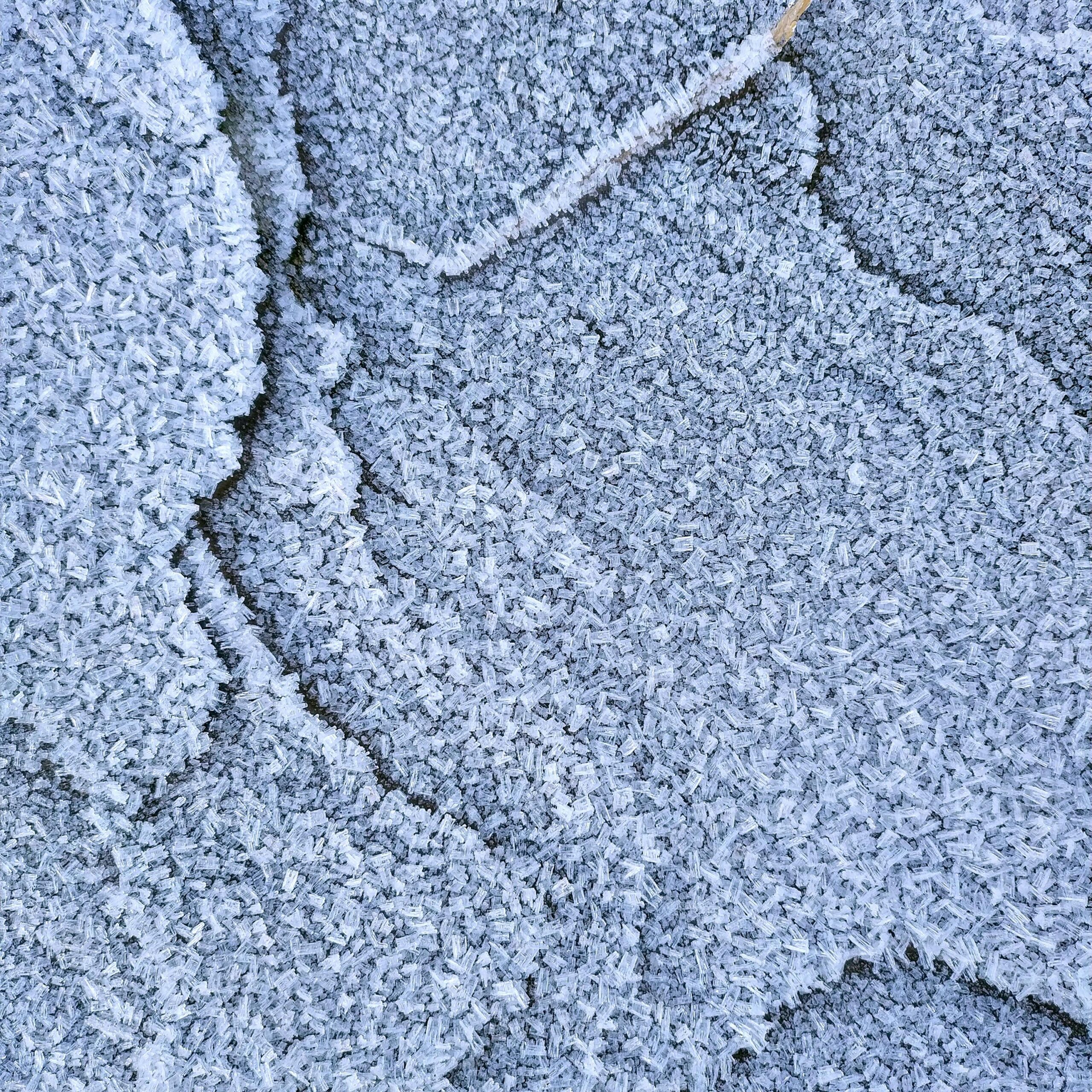Detailed close-up of a textured white surface resembling a carpet or fabric pattern with abstract design.
